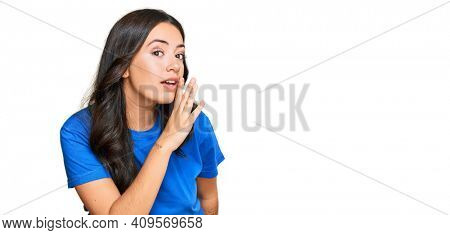 Beautiful brunette young woman wearing casual clothes hand on mouth telling secret rumor, whispering malicious talk conversation 