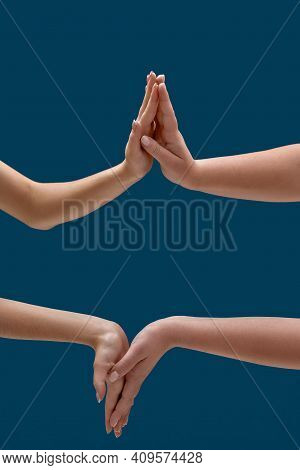 Close Up Of Two Women Holding Or Measuring Hands, Touching Each Other Palms Isolated Over Blue Backg