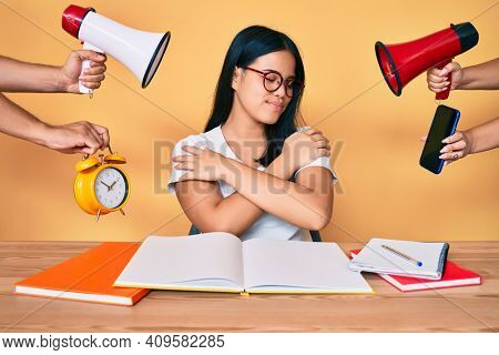 Young beautiful asian girl stuying for university getting stressed out hugging oneself happy and positive, smiling confident. self love and self care 