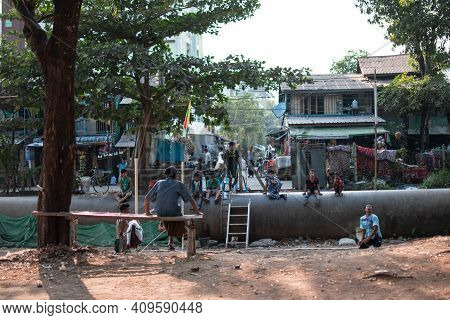Yangon, Myanmar - Decemeber 31 2019: Local People Play Traditional Chinlone Ball With Spectators Sit
