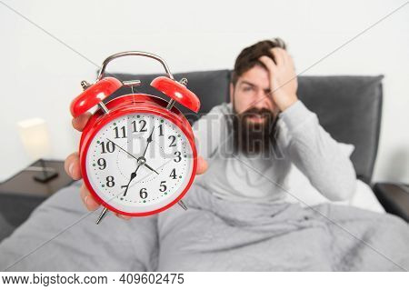 Tips For Becoming An Early Riser. Man Bearded Hipster Sleepy Face In Bed With Alarm Clock. Problem W