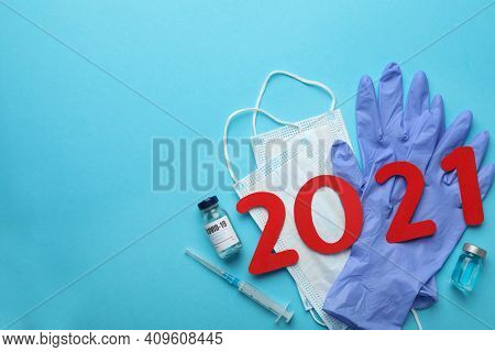 Flat Lay Composition With Coronavirus Vaccine And Number 2021 On Light Blue Background, Space For Te
