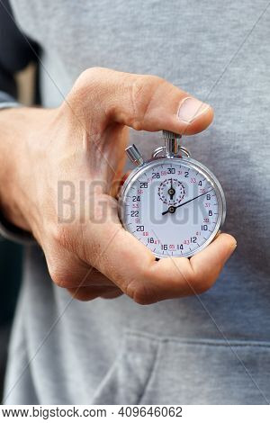 Trainer Holds Stopwatch In His Hand And Presses Start And Stop Button - Close Up