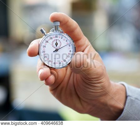 Trainer Holds Stopwatch In His Hand And Presses Start And Stop Button - Close Up