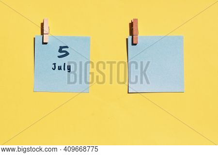 July 5st. Day Of 5 Month, Calendar Date. Two Blue Sheets For Writing On A Yellow Background. Top Vie