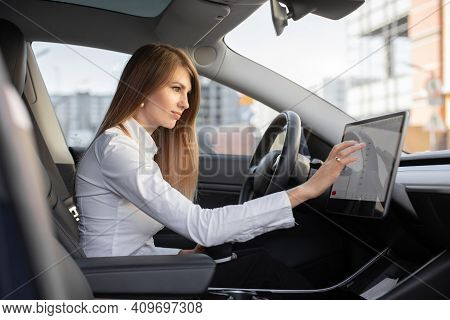 Smart Electric Car Concept. Pretty Woman In Formal Wear, Controlling Modern Electric Self-steering C