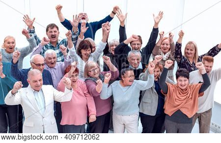 group of elderly friends raised their hands up and celebrate suc