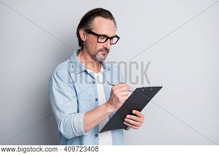 Photo Of Handsome Man Hold Clipboard Writing Wear Glasses Serious Face Isolated On Grey Color Backgr