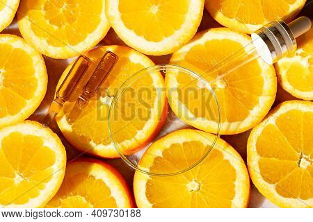 Glass Petri Dish With Transparent Pure Serum For Skin Care With Ampulas Over Natural Orange Slices, 