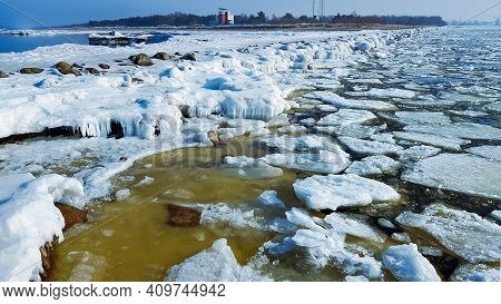 Icy Road To The Lighthouse On Mangalsala Pier In Baltic Sea Located At Riga Sea Port, Latvia, Europe