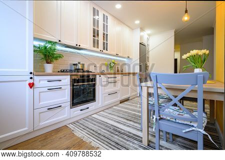 cozy well designed modern kitchen interior with appliances and dining table