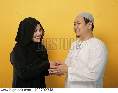 Happy Asian Muslim Couple Doing Greeting Gesture, Apologize And Forgiving Each Other On Eid Mubarak 