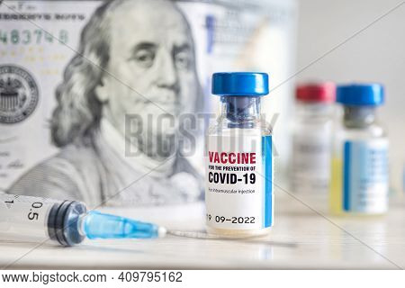 Covid-19 Coronavirus Infection Vaccine And A Syringe On The Table Against The Background Of Money. T