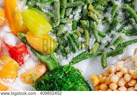 Variety Of Frozen Berries, Greens And Veggies On A Grinded Ice. Top View.