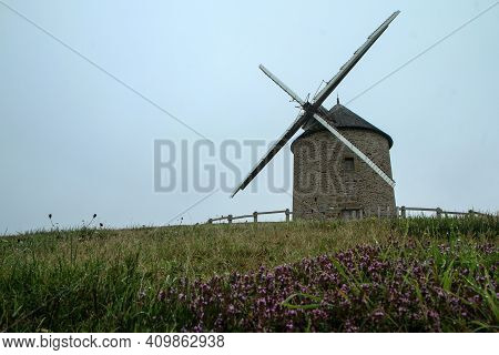 Moidrey Windmill In France. The Very Old And Still Functional Windmill During The Cloudy Day.