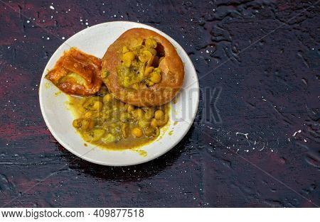 Indian Snack Kachori With Ghugni Curry And Mango Pickle In A Plate Isolated On Black Background With