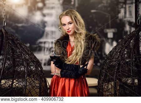 A Woman In A Red Dress With A Glass Of Wine And Fur. Old Fashioned Makeup And Wavy Hair. Style Of Th