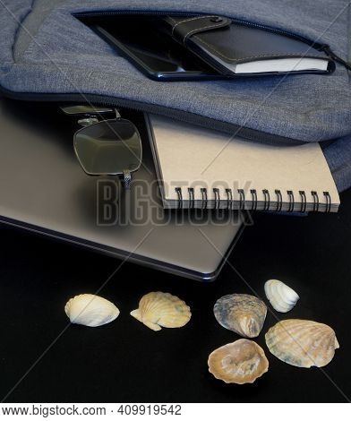A Gray Backpack With An Ultrabook, Smartphone, Sunglasses And A Notebook Lies On A Black Surface Nex