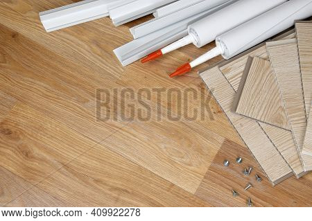 Set Of Items For Pvc Ceiling Indoor Works. Assembly Adhesive Bottles And Pvc Panels With Plastic Cor