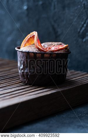 Choco  Brownie Cupcake With Blood Orange Slices On Ribbed Oak Cutboard On Dark Plaster Background Fr
