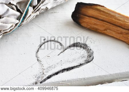 A Close Up Image Of A Heart Shaped Drawing With White Sage And Holy Wood Smudge Stick On A White Tab