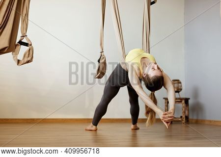 A Young Woman Performs An Anti-gravity Yoga Exercise Using A Hammock In A Yoga Class. Aero Yoga, Spo