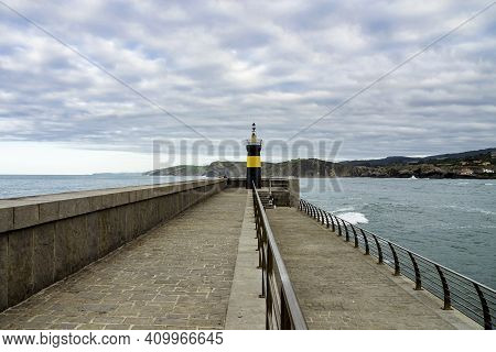 View Of The Dike And The Ligthouse At Comillas, Cantabria In Spain