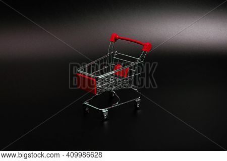 Small Red Shopping Cart On A Black Background. Copspace