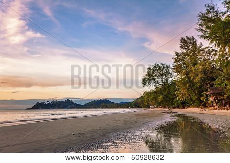 Tropical beach in ebb time on sunset background