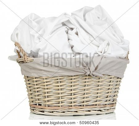 Rumpled bedding sheets in wicker basket isolated on white