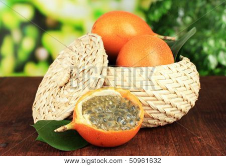 Passion fruits in wicker basket on table on bright background