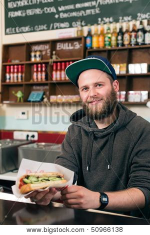 Hotdog - friendly salesman and customer in a fast food snack bar