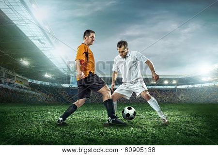 Two football players with ball in action outdoors.