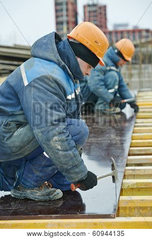 construction worker at construction site assembling falsework for concrete pouring