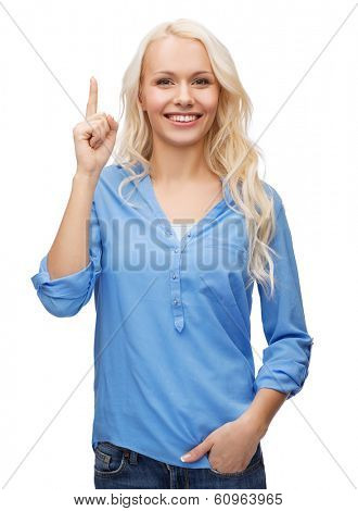advertisement concept - attractive young woman in casual clothes pointing her finger up