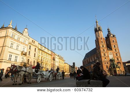 KRAKOW, POLAND - FEB 26, 2014: Carriages at Main Market Square. It dates to the 13th century, and at roughly 40,000 m it is the largest medieval town square in Europe.