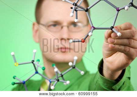 close up portrait of young chemist, developing new molecular structures. focus on molecule