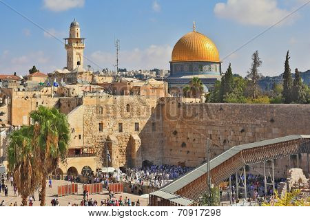 JERUSALEM, ISRAEL - SEPTEMBER 18, 2013: Sunny morning in the holiday of Sukkot. Religious Jews in white prayer shawls are going to pray at the Western Wall of the Temple.