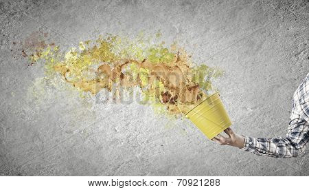Close up of hand splashing colorful paint from bucket