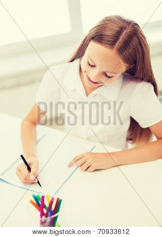 education, creation and school concept - smiling little student girl drawing and daydreaming at school