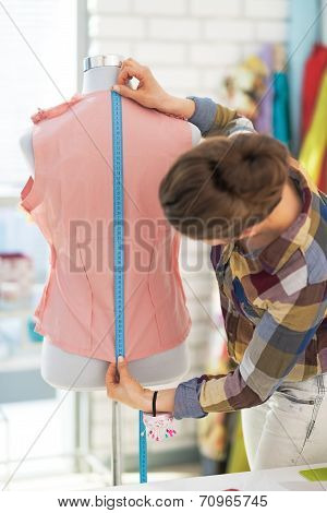 Tailor Woman Working With Dress In Studio. Rear View