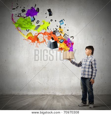 Young boy splashing colorful paint from bucket