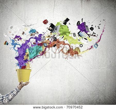 Close up of hand splashing colorful paint from bucket
