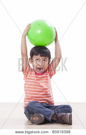 Cute little boy playing green ball