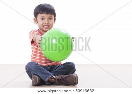 Cute little boy playing green ball