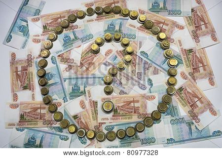 The question mark in the circle, made of coins on the background of banknotes