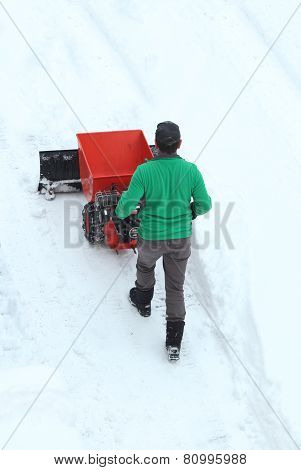 Man Moving A Engine Driven Snowplow