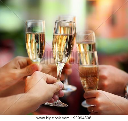 People Holding Glasses Of Champagne Making A Toast