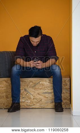 young man in crative box working on smart phone, startup business modern office room  interior