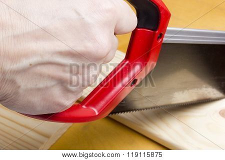 Close Up Of Builders With Arm Saw Sawing Board